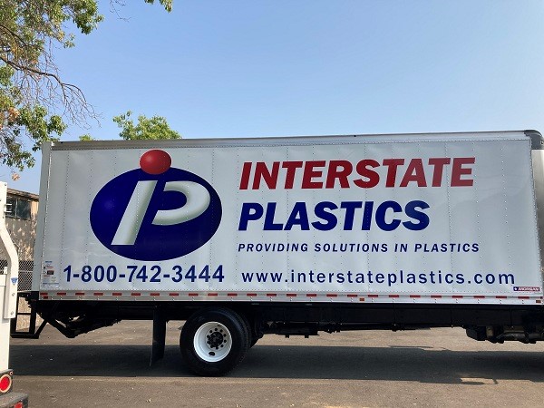 Photo of a box truck with vehicle graphics, Interstate Plastics, in blue and red vinyl.